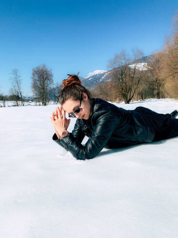 Frau liegt im Schnee und verschwendet ihre Zeit mit Niksen